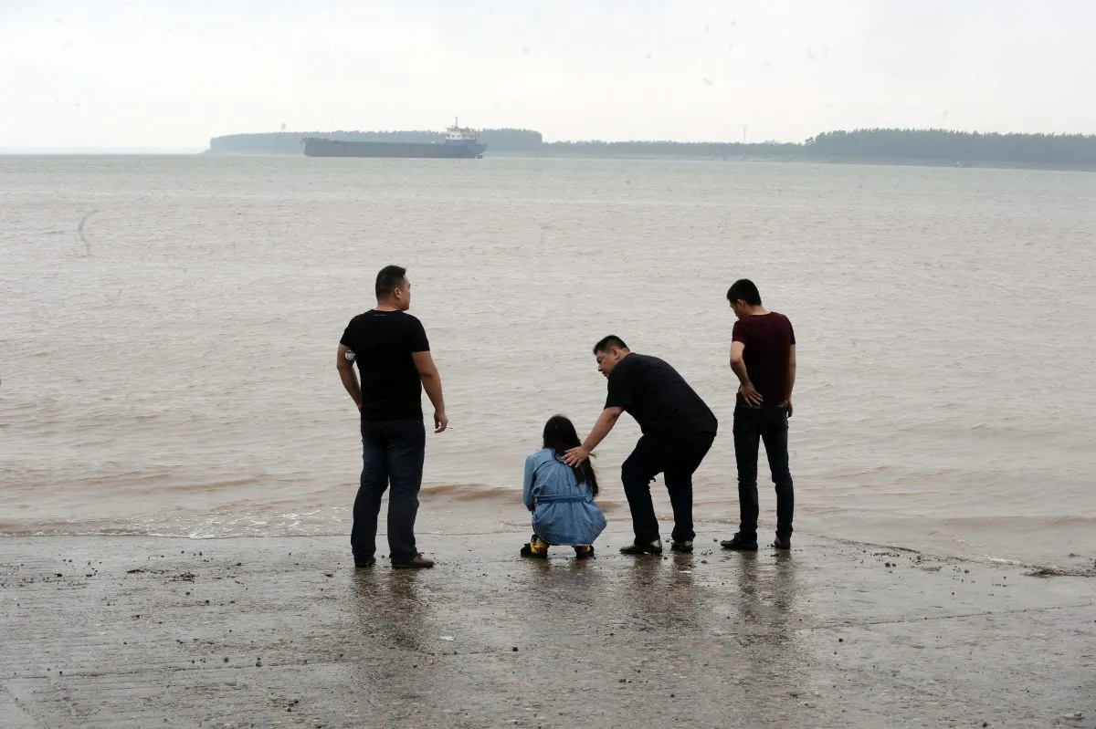 A relative (2nd L) of passengers on board the sank vessel "Eastern Star" being comforted by a man next to the river side in Jianli, central China's Hubei province on June 3, 2015. (STR/AFP/Getty Images)