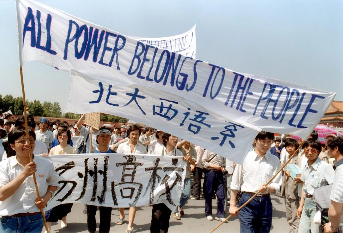 A 25 May 1989 file photo shows students waving banners as they march in Beijing streets near Tiananmen Square during a rally to support the pro-democracy protest against the Chinese government. (Catherine Henriette/AFP/Getty Images)