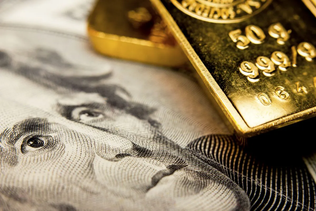 Close-up of a 20-dollar banknote and gold bullions. (Corlaffra/Shutterstock)