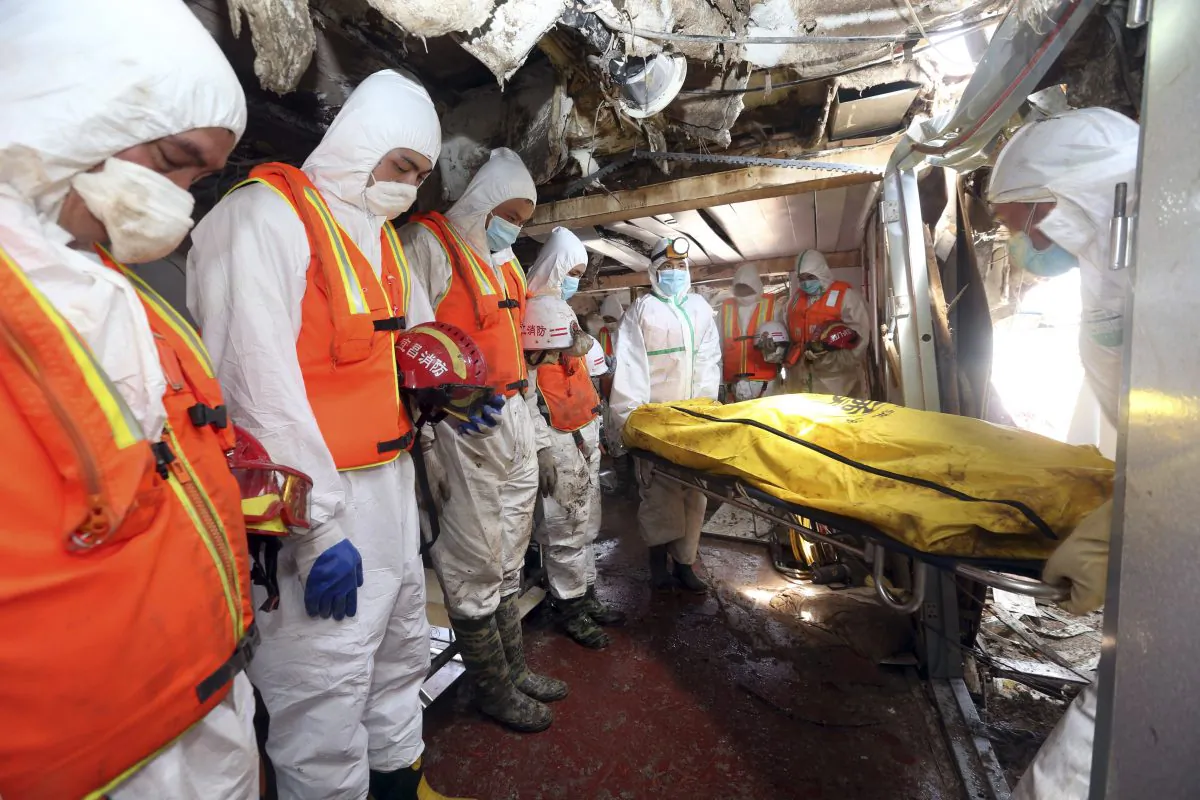 Rescue workers react as a body is removed from the Eastern Star after it was righted and lifted by cranes in the Yangtze River in Jianli county in southern China's Hubei province, June 6, 2015. The death toll rose after hundreds of more bodies from the Eastern Star were found including that of a 3-year-old girl in the top deck, officials said. (Chinatopix Via AP)