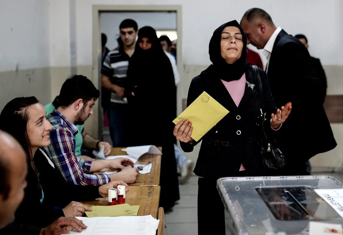 A Turkish woman reacts before casting her vote for Turkey's legislative election at a polling station in Istanbul on June 7, 2015. (YASIN AKGUL/AFP/Getty Images)
