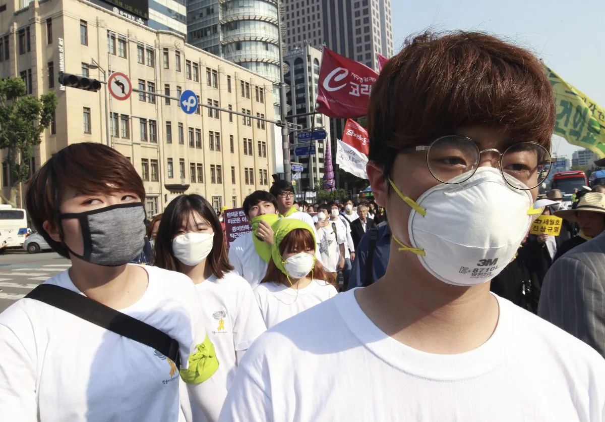 Protesters wear masks as a precaution against the MERS, Middle East Respiratory Syndrome, virus as they march after a rally against government's labor policy in Seoul, South Korea, Sunday, June 7, 2015. (AP Photo/Ahn Young-joon)