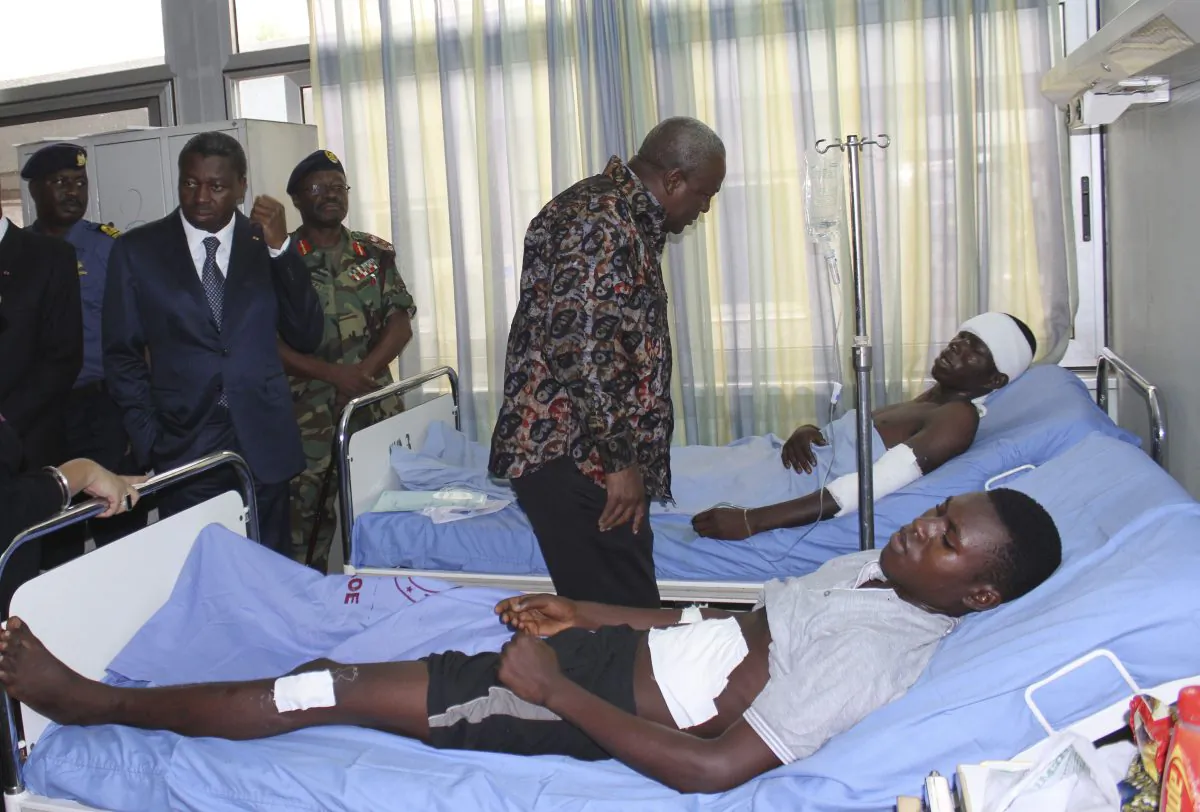 Ghana President John Dramani Mahama, center, and Togo President Faure Gnassingbe, second left, visit victims of the gas station explosion at the military hospital in Accra, Ghana, Friday, June 5, 2015. (AP Photo)