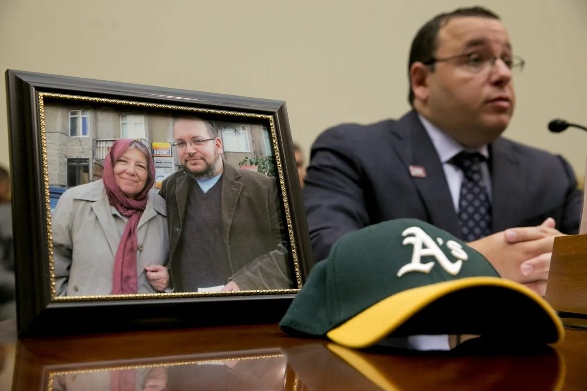TEHRAN, Iran (AP) — The mother of detained Washington Post correspondent Jason Rezaian said Monday that Iran has charged her son for simply "reporting on a country that he loves," as he addressed the judge overseeing his closed-door espionage trial.

Details of Rezaian's second court hearing remained vague in Iranian media accounts, although the semi-official Tasnim news agency said the 39-year-old bureau chief defended himself in English. The agency said a translator later handed Judge Abolghassem Salavati a transcript of Rezaian's remarks in Persian.

Rezaian faces charges including espionage and propaganda against the Islamic Republic, which the Post has said carry 10 to 20 years in prison if he is convicted. U.S. officials, the Post and rights groups have strongly criticized Rezaian's trial, demanding he be freed.

Rezaian's detention of over 300 days and his trial come as Iran negotiates with world powers over its contested nuclear program, leading many, including his mother, Mary, to suggest current events may play a role in his case.

"Someone believes that there is an advantage to holding him," Mary Rezaian told The Associated Press outside her son's hearing at Tehran's Revolutionary Court. "Personally, I do not think so."

Standing next to his wife, Yeganeh Salehi, Mary Rezaian said her son is "very tired, very distressed." She also said she didn't know how many more court hearings will be held or how the trial is going. Both she and Rezaian's wife have not been allowed to attend the hearings, although Mary Rezaian has seen him twice briefly since she arrived in Iran a month ago.

"He is being accused of being a master spy when all he was doing was reporting on a country that he loves. So it is very hard for him. Very, very hard for him. And of course he misses his wife," Mary Rezaian said. "So two years they have been married, one year he has been in prison. It is a very, very difficult thing."

Salehi declined to discuss her husband's trial, only saying: "I am not in a good state."

Rezaian, his wife and two photojournalists were detained July 22, 2014, in Tehran. All were later released except Rezaian. At the hearing Monday, two other people detained with Rezaian were in court, according to Iran's official IRNA news agency, without elaborating or identifying them.

Rezaian's defense lawyer, Leila Ahsan, previously said that Salehi and one of the two unidentified photojournalists also would stand trial. Ahsan did not immediately return calls for comment Monday.

As in the May hearing, reporters gathered in front of the courthouse gate did not see Rezaian, his lawyer or the other two co-defendants. Authorities usually bring those charged in sensitive cases into the building through a gate closed to the public.

Rezaian is a dual U.S.-Iranian citizen who was born and spent most of his life in the United States. Iran does not recognize other nationalities for its citizens.

Salehi, a reporter for The National newspaper in Abu Dhabi, remains in Iran, barred from traveling abroad, the Post has said.

At Rezaian's first hearing, the court alleged that Rezaian had written to U.S. President Barack Obama and also cited a trip he made to the U.S. Consulate in Dubai, Iran's semi-official Mehr news agency reported at the time.

FILE- In this Tuesday, June 2, 2015 file photo, Ali Rezaian, brother of Washington Post journalist Jason Rezaian, speaks by a picture of their mother and his brother, who is being held in Iran, on Capitol Hill in Washington, during a House Foreign Affairs Committee hearing with people whose family members are being detained in Iran. Rezaian's mother said Monday, June 8, 2015, that her son is "very tired, very distressed" as the journalist returned to a Tehran courtroom for the second closed-door hearing in his espionage trial. Rezaian is a dual U.S.-Iranian citizen. (AP Photo/Jacquelyn Martin, File)