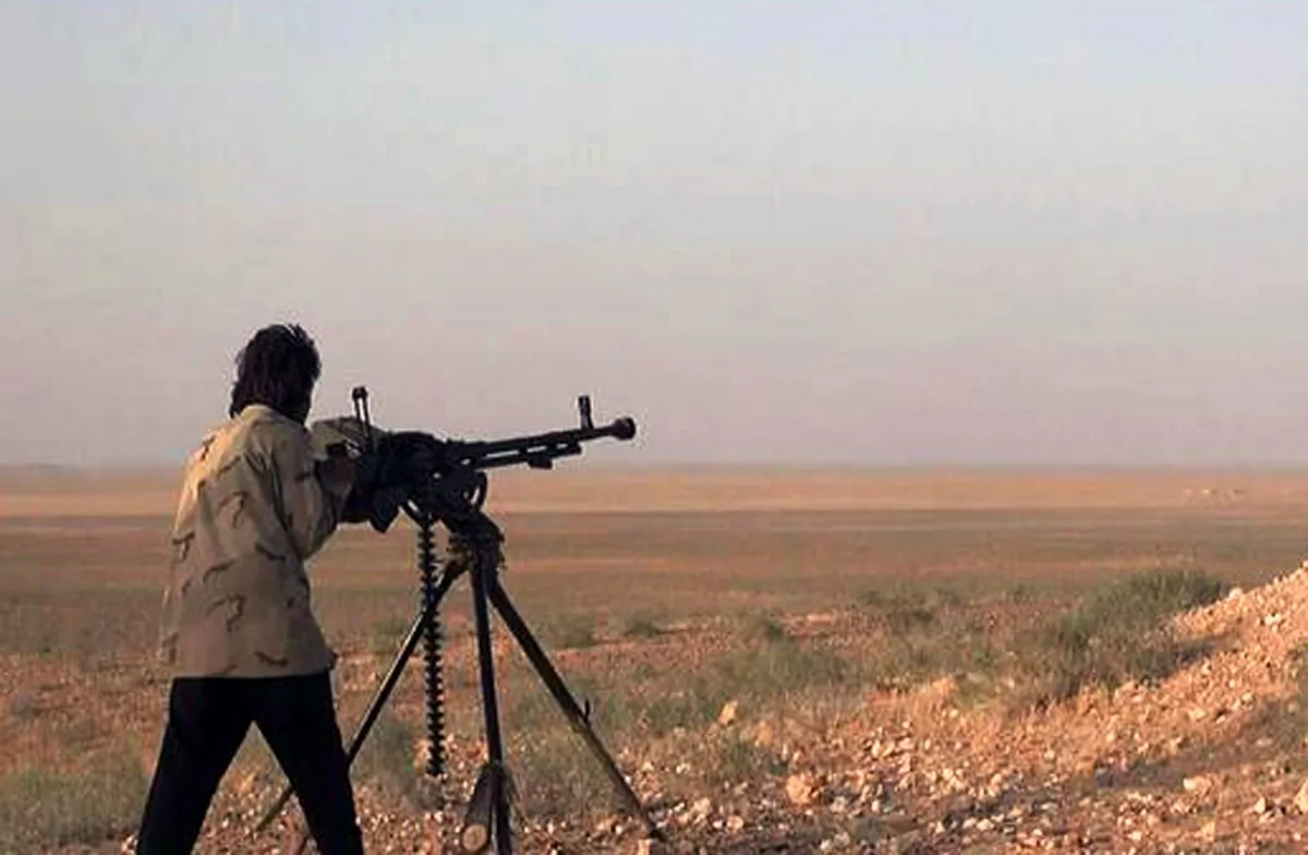 In this picture released on Wednesday, May 20, 2015 by the website of ISIS extremists, an ISIS extremist aims his weapon during a battle against the Syrian government forces on a road between Homs and Palmyra, Syria. (The website of Islamic State militants via AP)