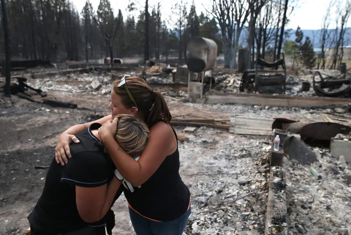 A mother and daughter hold each other as they in the burned-out ruins of what used to be their home Weed, Calif., on Sept. 16, 2014. (Justin Sullivan/Getty Images)
