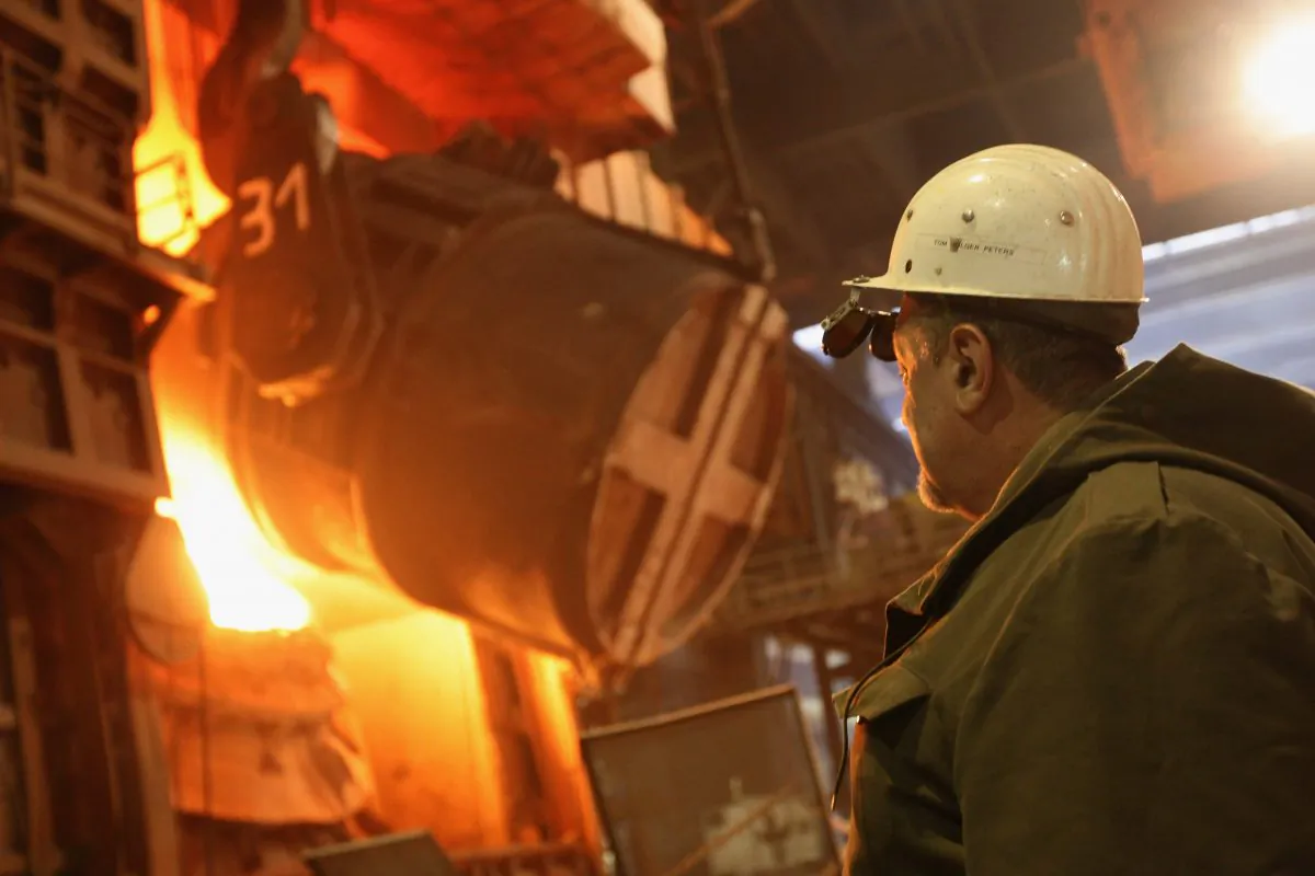 A worker watches as molten iron flows into a furnace for purification and alloying to become steel at the ThyssenKrupp steelworks on Jan. 13, 2010, in Duisburg, Germany. Carbon is needed to produce steel, which complicates efforts to realize a carbon-free future. (Sean Gallup/Getty Images) 