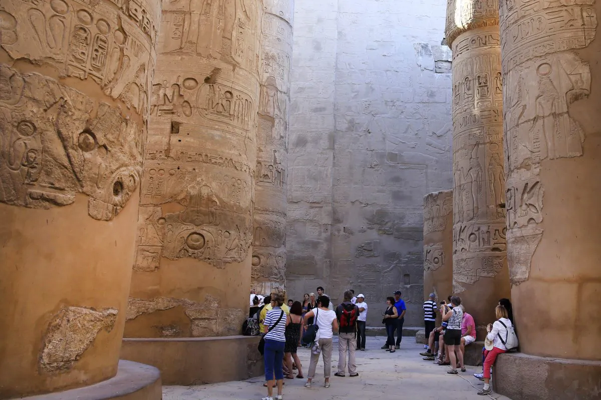FILE - In this Sunday, Nov. 30, 2014, file photo, tourists point out the hieroglyphic on columns in the Hypostyle Hall at the Karnak Temple in Luxor, Egypt. (AP Photo/Hassan Ammar, File)