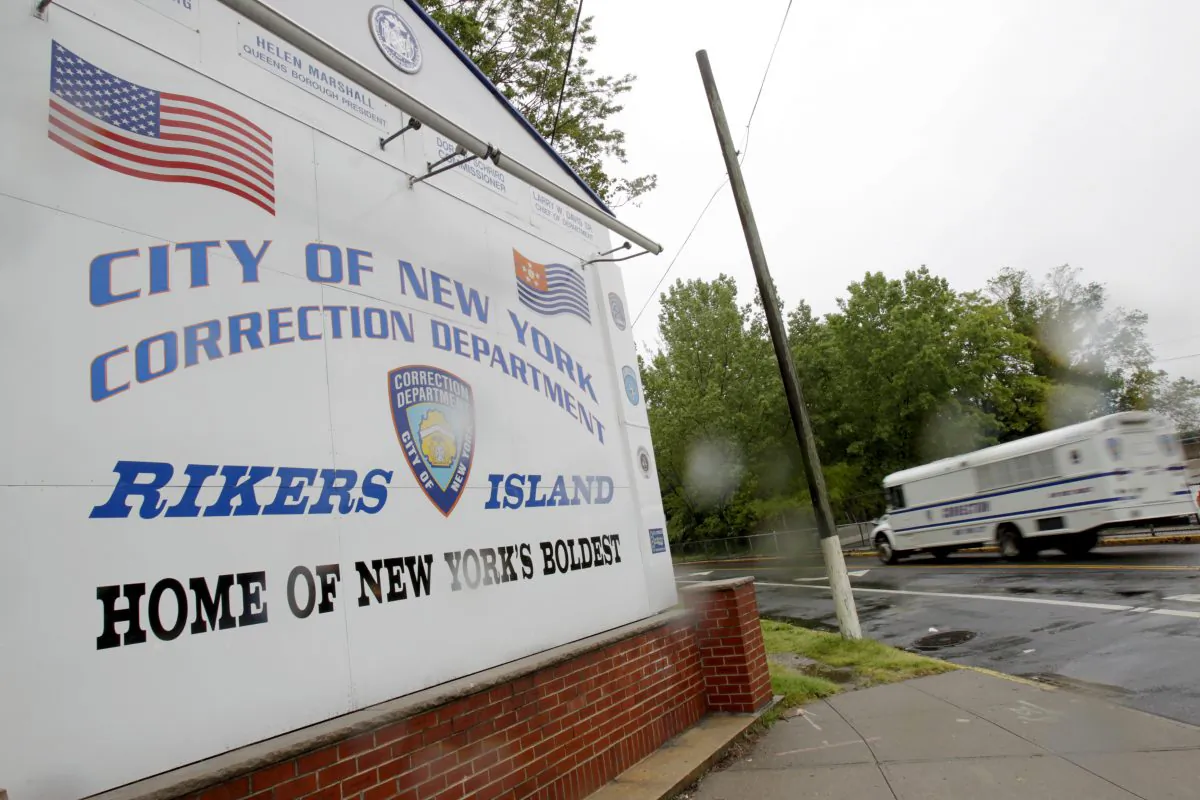 A bus drives past the the entrance to Rikers Island in New York. Overall performance of the private health care provider for New York City's jails failed to improve last year amid heightened scrutiny over inmate deaths that put the company's contract under review, according to an evaluation obtained by The Associated Press. (AP/Seth Wenig)