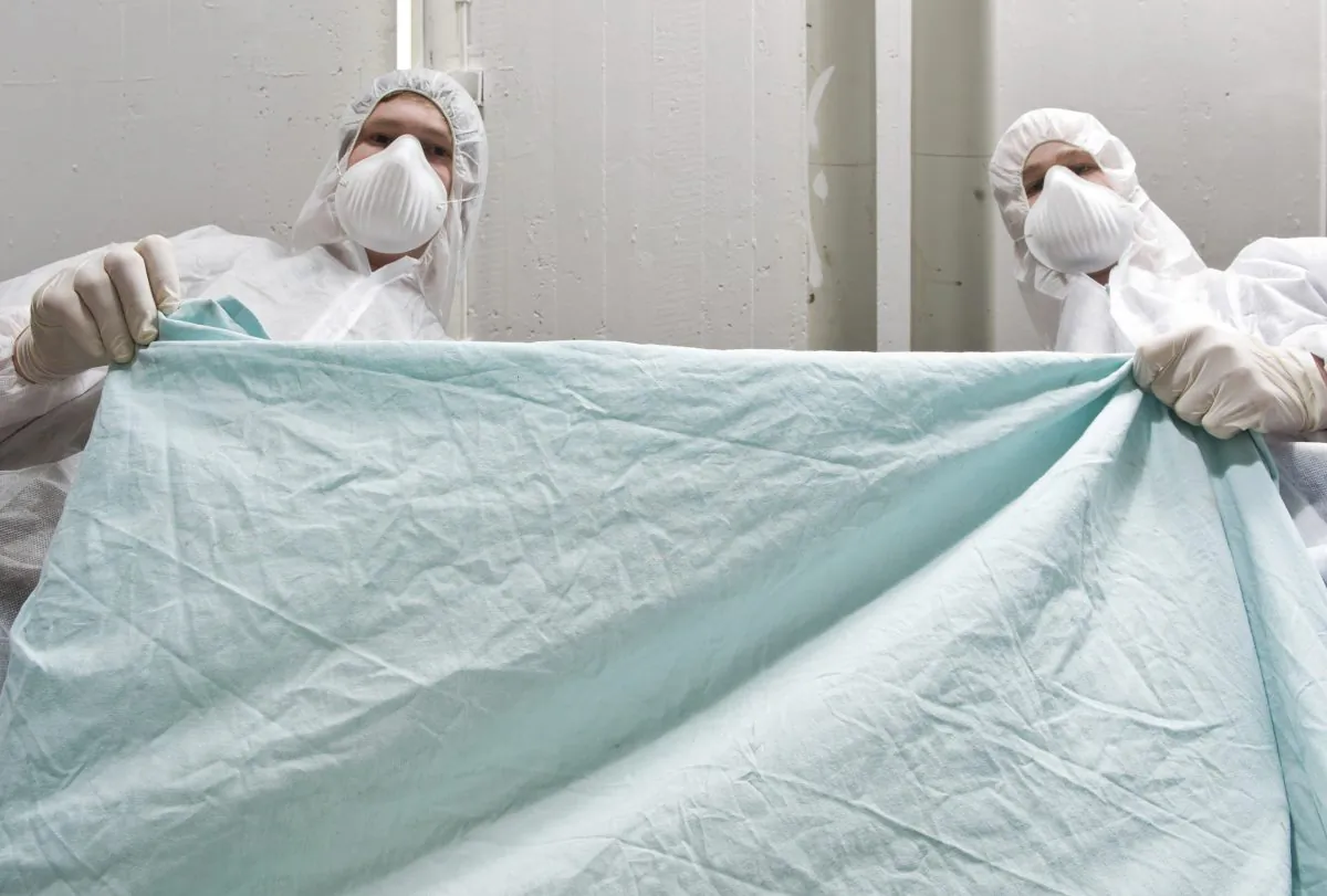 A file photo of forensic investigators covering a dead victim. (36clicks/iStock)