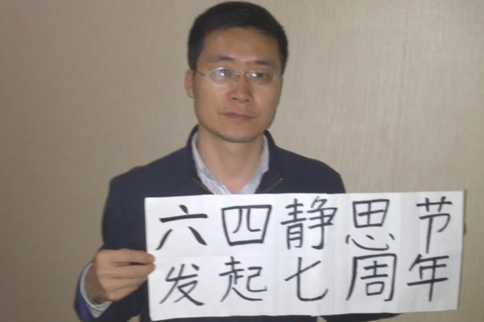 Former Chinese human rights lawyer, Tang Jingling, holds a poster in early 2014 in support of protesters killed at Tiananmen during the 1989 massacre (AP).
