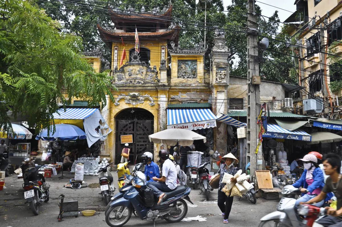 Typical scene in Hanoi, motor-cycles (scooters), and shops that expose on the road the items for sale. (iStock)