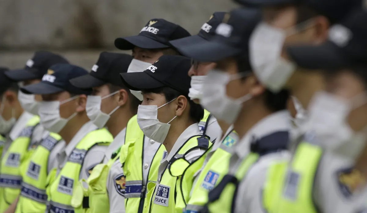 South Korean police officers wearing masks as a precaution against Middle East Respiratory Syndrome (MERS) stand guard during a rally in Seoul, South Korea, Thursday, June 11, 2015. (AP Photo/Lee Jin-man)