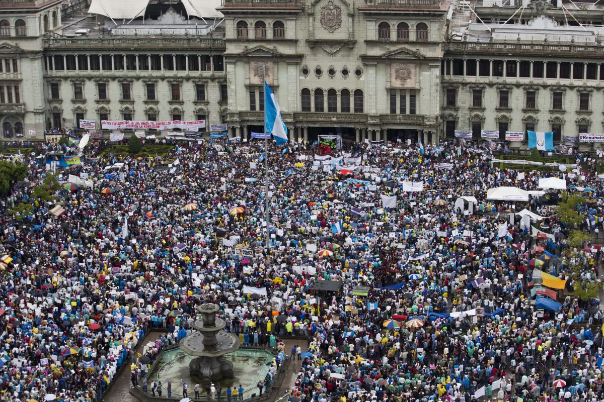 In this May 16, 2015 photo, protesters gather outside the National Palace to demand the resignation of Guatemalan President Otto Perez Molina in Guatemala City. Every Saturday for nearly two months, Constitution Square outside Guatemala City's National Palace has overflowed with thousands of protesters demanding an end to corruption and the resignation of the President.  (AP Photo/Moises Castillo)