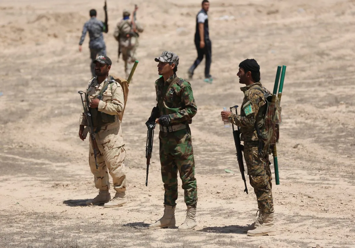 Fighters from the Badr Brigades Shiite militia patrol at the front line, in Kessarrat, located (70 kilometers) north west of Baghdad, Iraq, Friday, June 12, 2015. Despite concerns over heightened sectarian strife, Shiite militiamen continue to pour into Iraqs Anbar province with the hope of recapturing the city of Fallujah from the Islamic State group. As the U.S. prepares to send an additional 450 trainers to Iraq, the Iranian-backed militias say that coalition assistance only hurts their efforts, contradicting statements by the Iraqi government that more international support is needed. (AP Photo/Hadi Mizban)