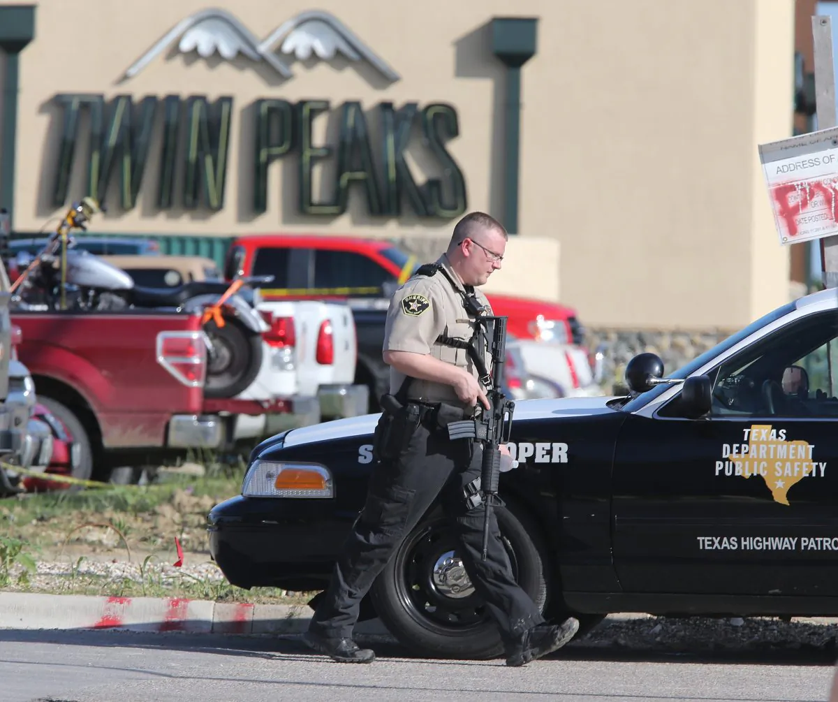 In this May 17, 2015 file photo, authorities investigate a shooting in the parking lot of the Twin Peaks restaurant, in Waco, Texas. (AP Photo/Jerry Larson, File)