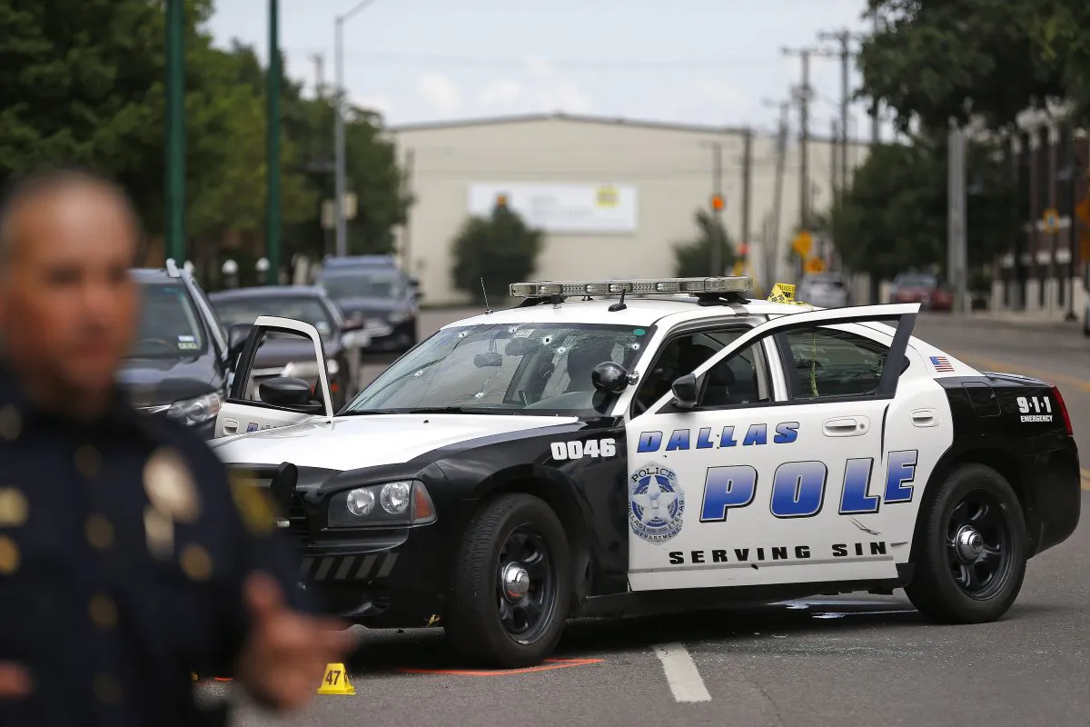 A cruiser with bullet holes and damage at Dallas police headquarters after a gunman opened fire, June 13, 2015. (AP Photo/Ron Jenkins)