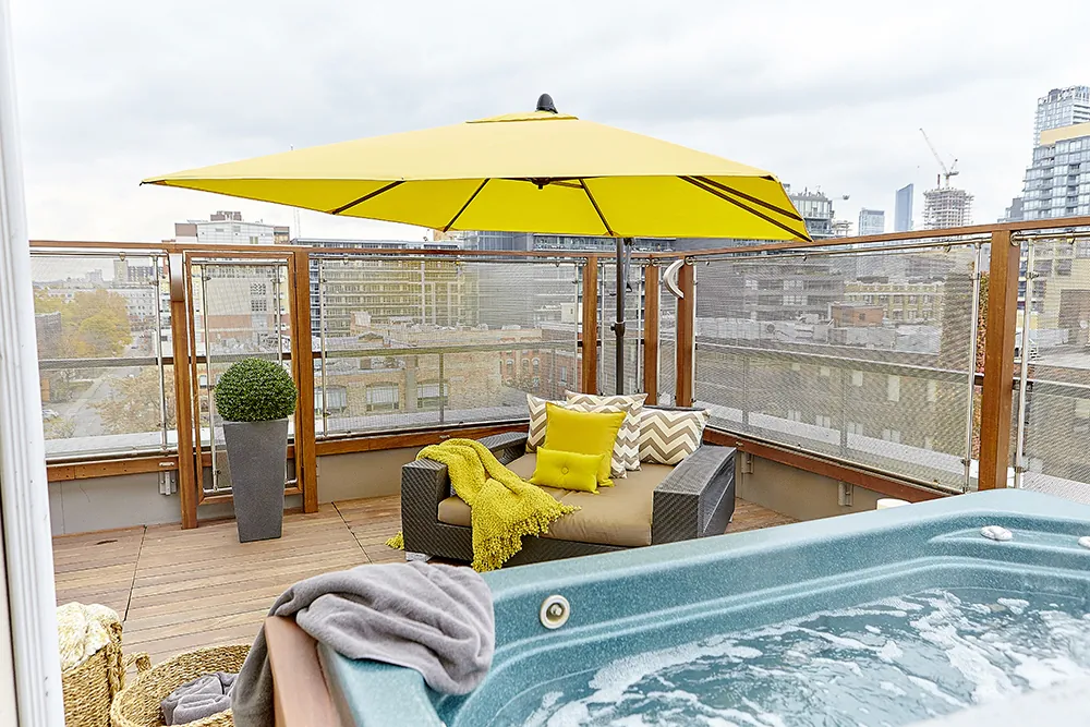 A rooftop patio is decorated to maximize its functionality for entertaining. (To the Point Media)