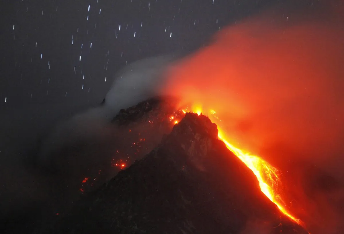 In this photo taken with slow shutter speed, hot lava flows from the crater of Mount Sinabung as seen from Tiga Serangkai, North Sumatra, Indonesia, early Monday, June 15, 2015.  (AP Photo/Binsar Bakkara)