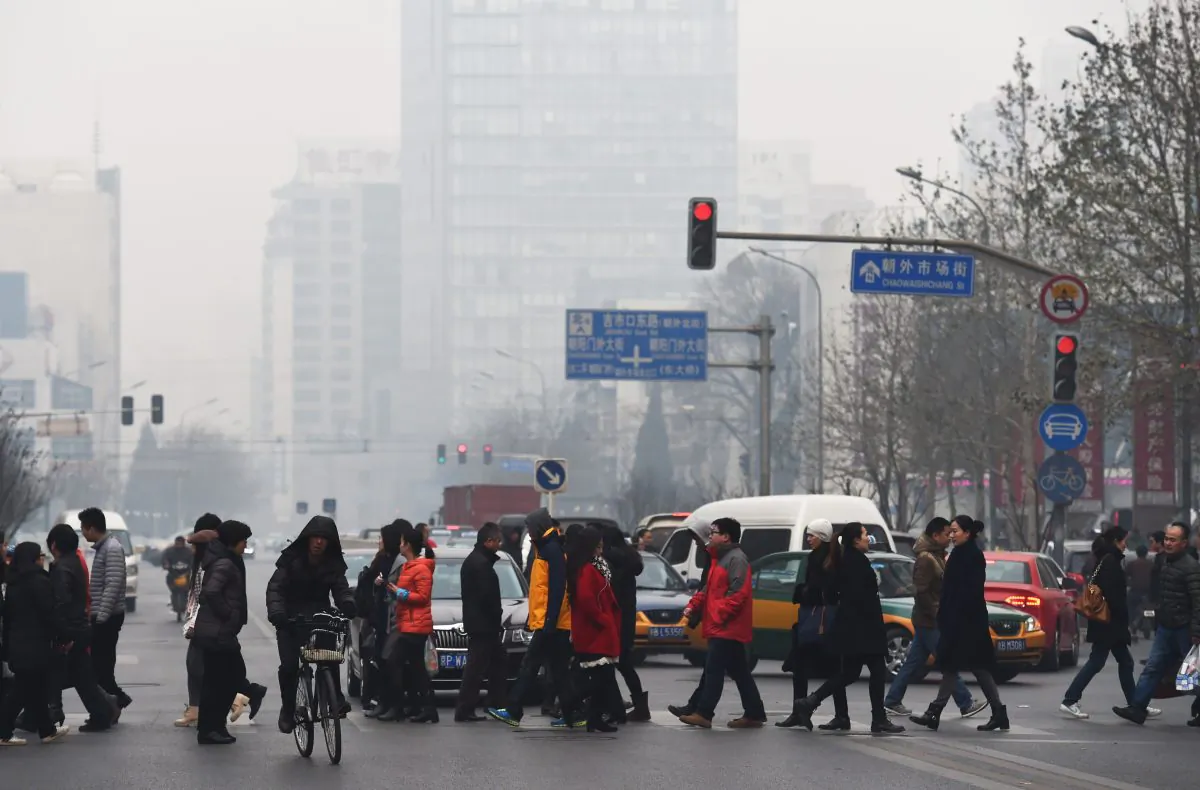 Pedestrians cross a road on a polluted day in Beijing on December 9, 2014. (GREG BAKER/AFP/Getty Images)