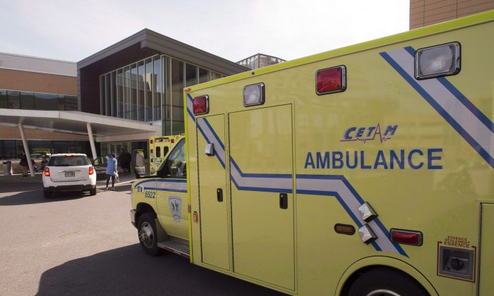 An ambulance drives up to a hospital in Longueuill, Quebec. Health care and social service workers are appealing to Ottawa to restore health coverage for all refugees and refugee claimants. (The Canadian Press/Ryan Remiorz)