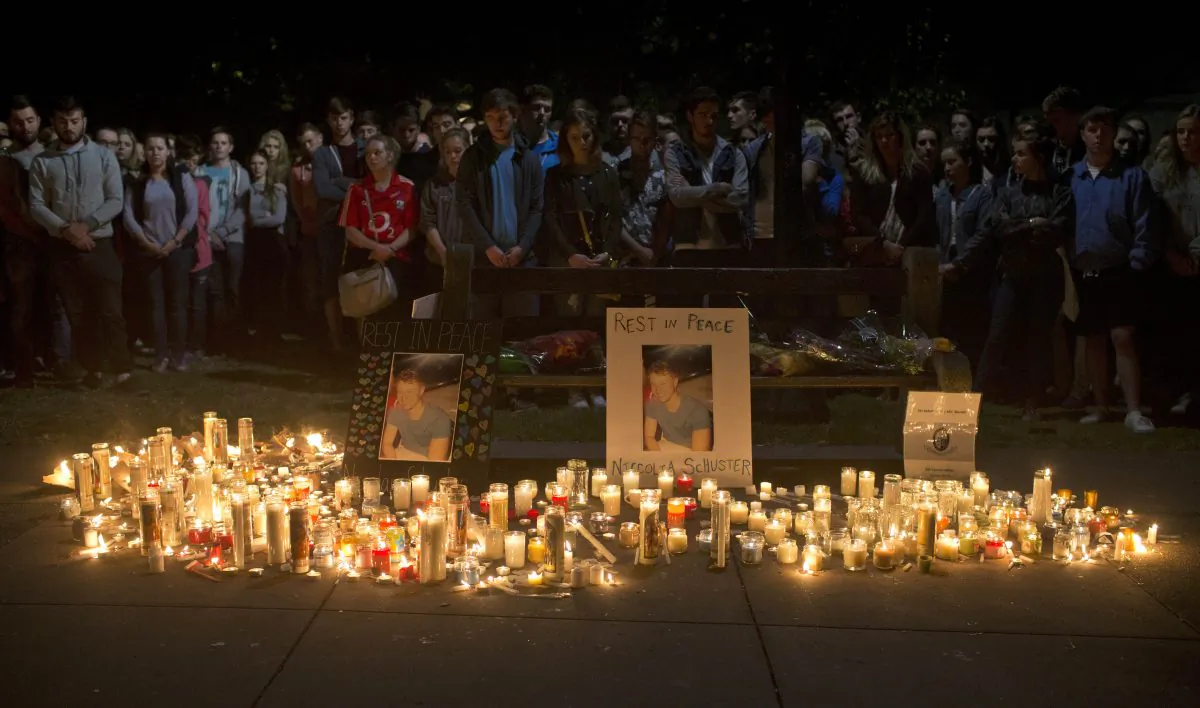 Mourners stand by during a candlelight vigil for six Irish students Wednesday, June 17, 2015, in Berkeley, Calif. (AP Photo/Beck Diefenbach)