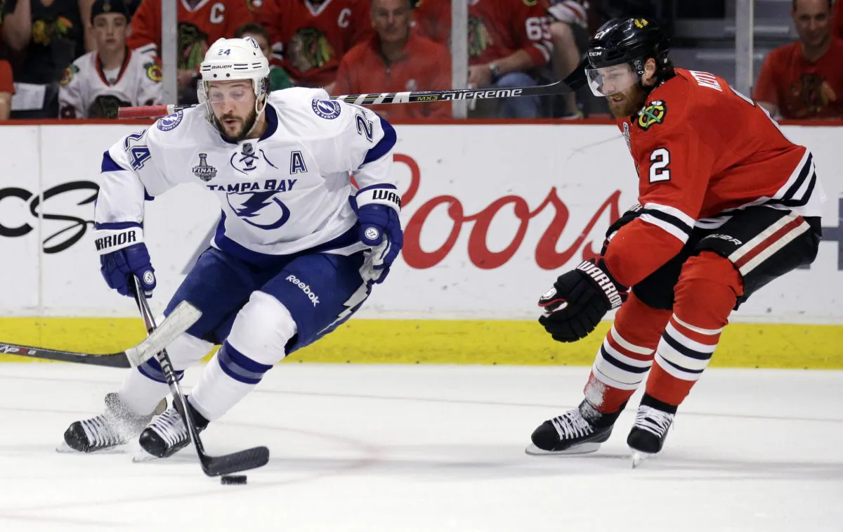 Tampa Bay Lightning's Ryan Callahan, left, handles the puck as Chicago Blackhawks' Duncan Keith watches during the first period in Game 6 of the NHL hockey Stanley Cup Final series on Monday, June 15, 2015, in Chicago. (AP Photo/Nam Y. Huh)