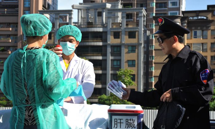 Falun Gong practitioners act out a scene of stealing human organs to sell during a demonstration in Taipei on July 20, 2014. (Mandy Cheng/AFP/Getty Images)
