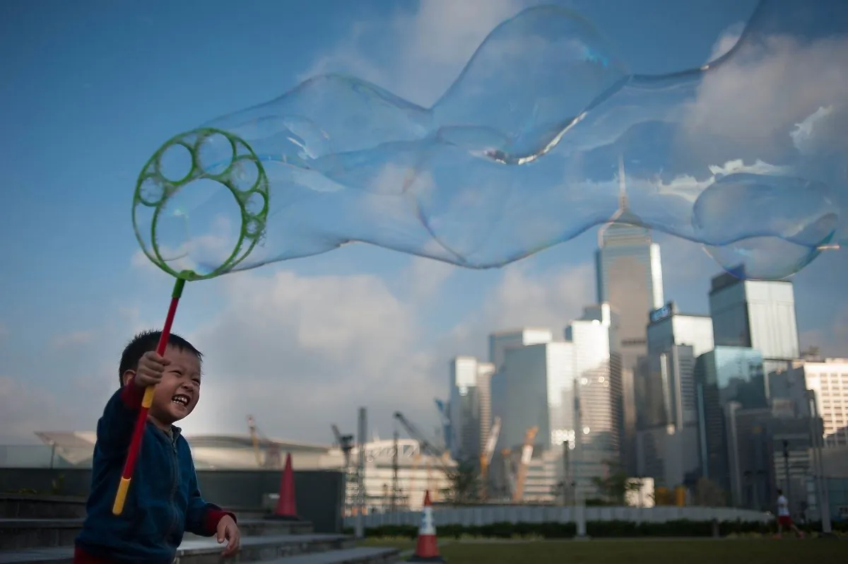 In this file photo, a boy waves a wand of bubbles up in the air in Hong Kong. (Anthony Kwan/Getty Images)