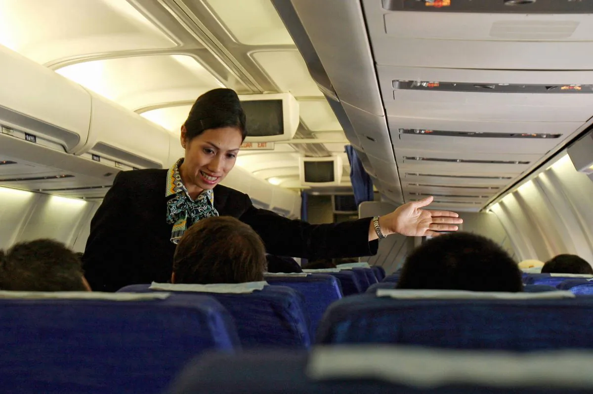 A Garuda Indonesia flight attendant helps a passenger during a flight from Padang to Jakarta in this file photo. (Adek BerryAFP/Getty Images)