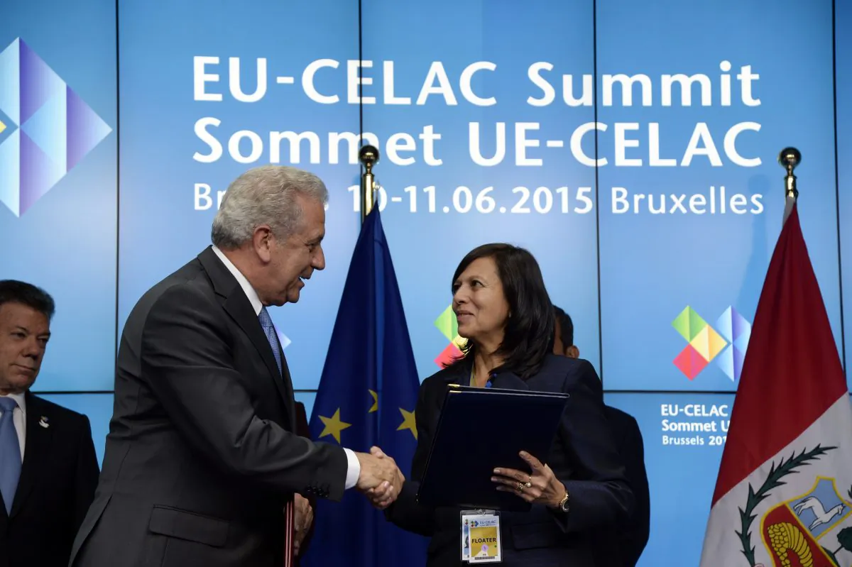 EU Commissioner for Migration, Home Affairs and Citizenship Dimitris Avramopoulos (L) shakes hands with Peru's Foreign Minister Ana Maria Liliana Sanchez Vargas de Rios following the signature of a bilateral visa waiver agreements between the European Union with Peru and Colombia during an EU-CELAC Summit held at the EU Council building in Brussels, June 10, 2015. (Thierry Charlier/AFP/Getty Images)