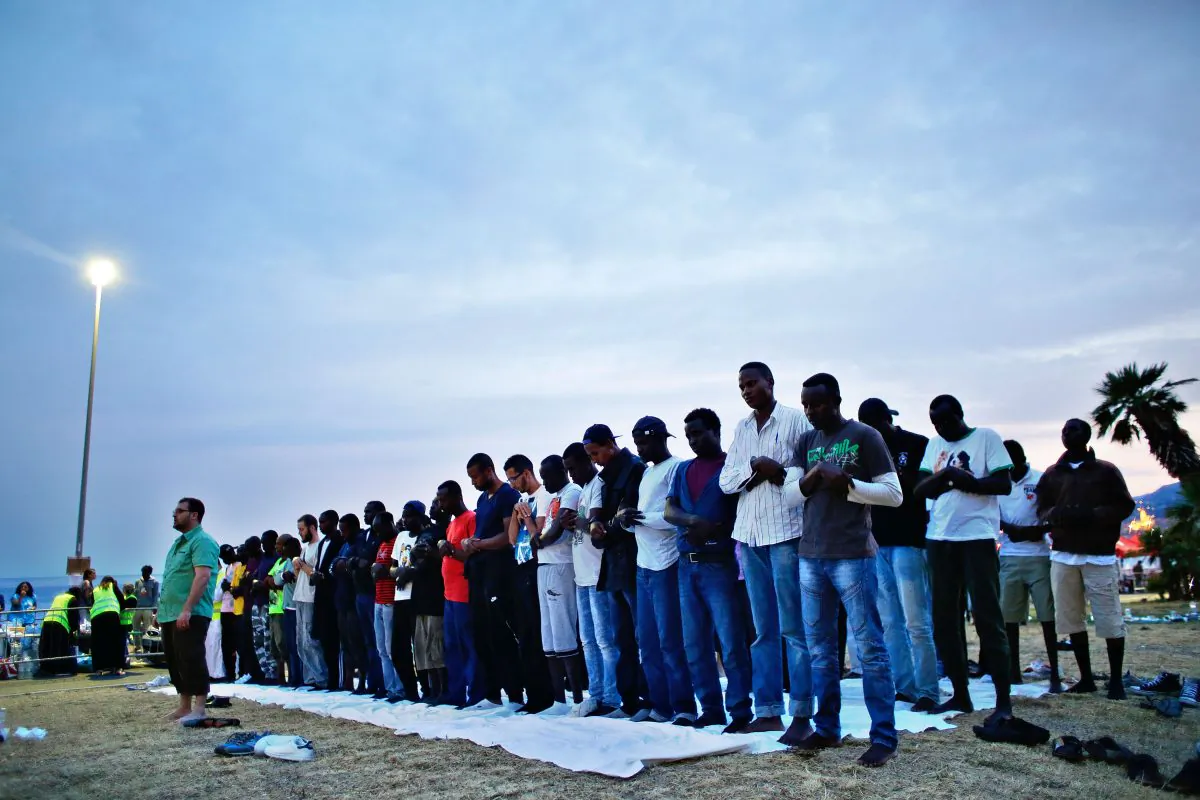 Migrants pray at the Franco-Italian border in Ventimiglia, Italy, Sunday, June 21, 2015. (AP Photo/Thibault Camus)