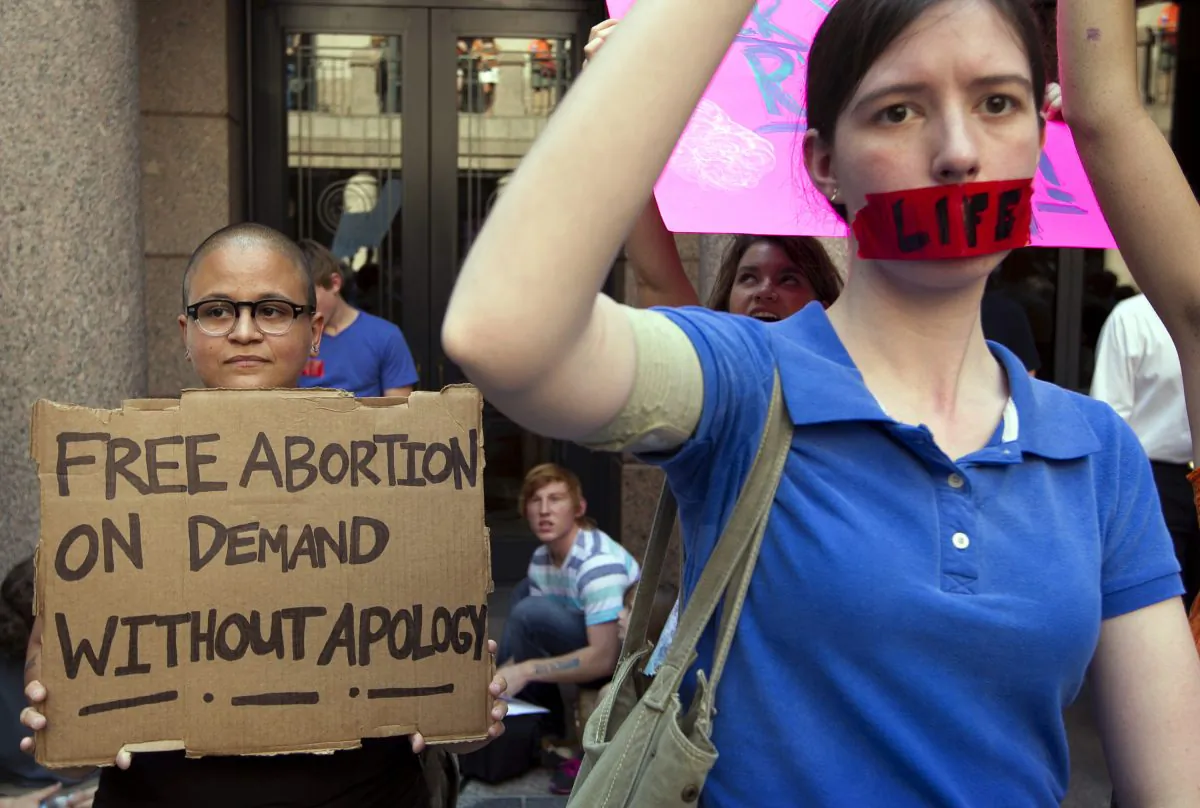 In a Tuesday July 2, 2013 photo, pro-abortion rights supporter Yatzel Sabat, left, and anti-abortion protestor Amanda Reed demonstrate at the state Capitol in Austin, Texas. (Jay Janner/Austin American-Statesman via AP)