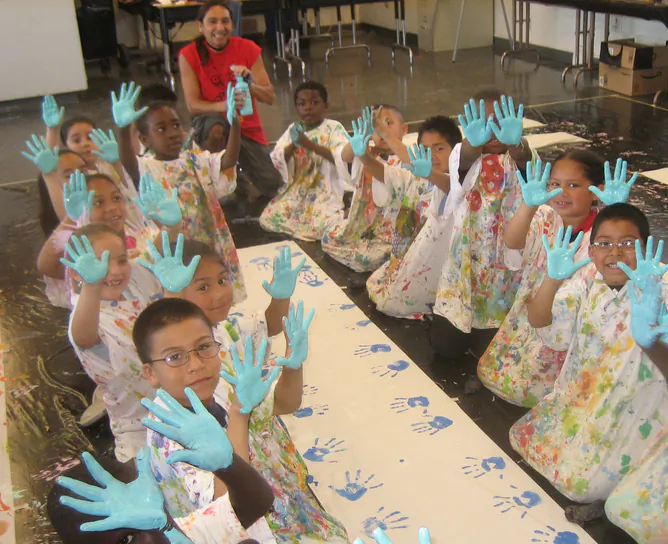 Freese Elementary first graders starting to paint a giant puppet with teaching artist Felix Diaz. University of California eScholarship Repository, CC BY