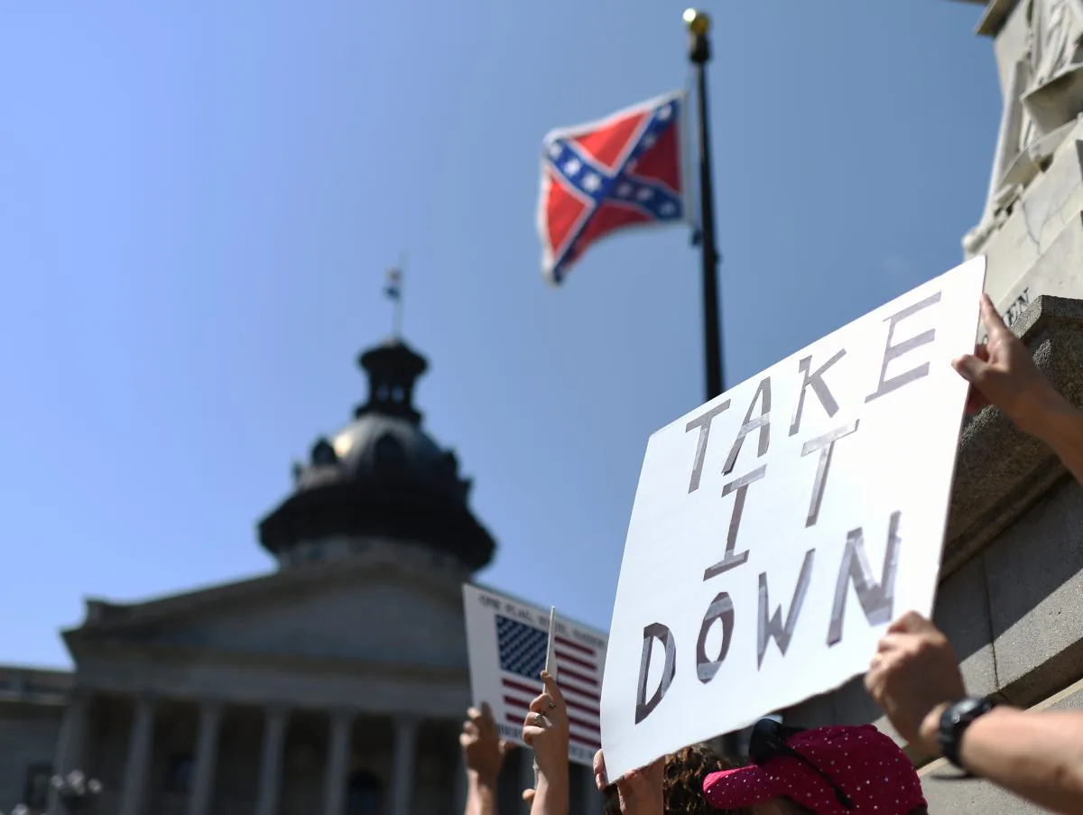 Protesters hold a sign during a rally to take down the Confederate flag at the South Carolina Statehouse in Columbia, S.C., on June 23, 2015. (AP Photo/Rainier Ehrhardt)