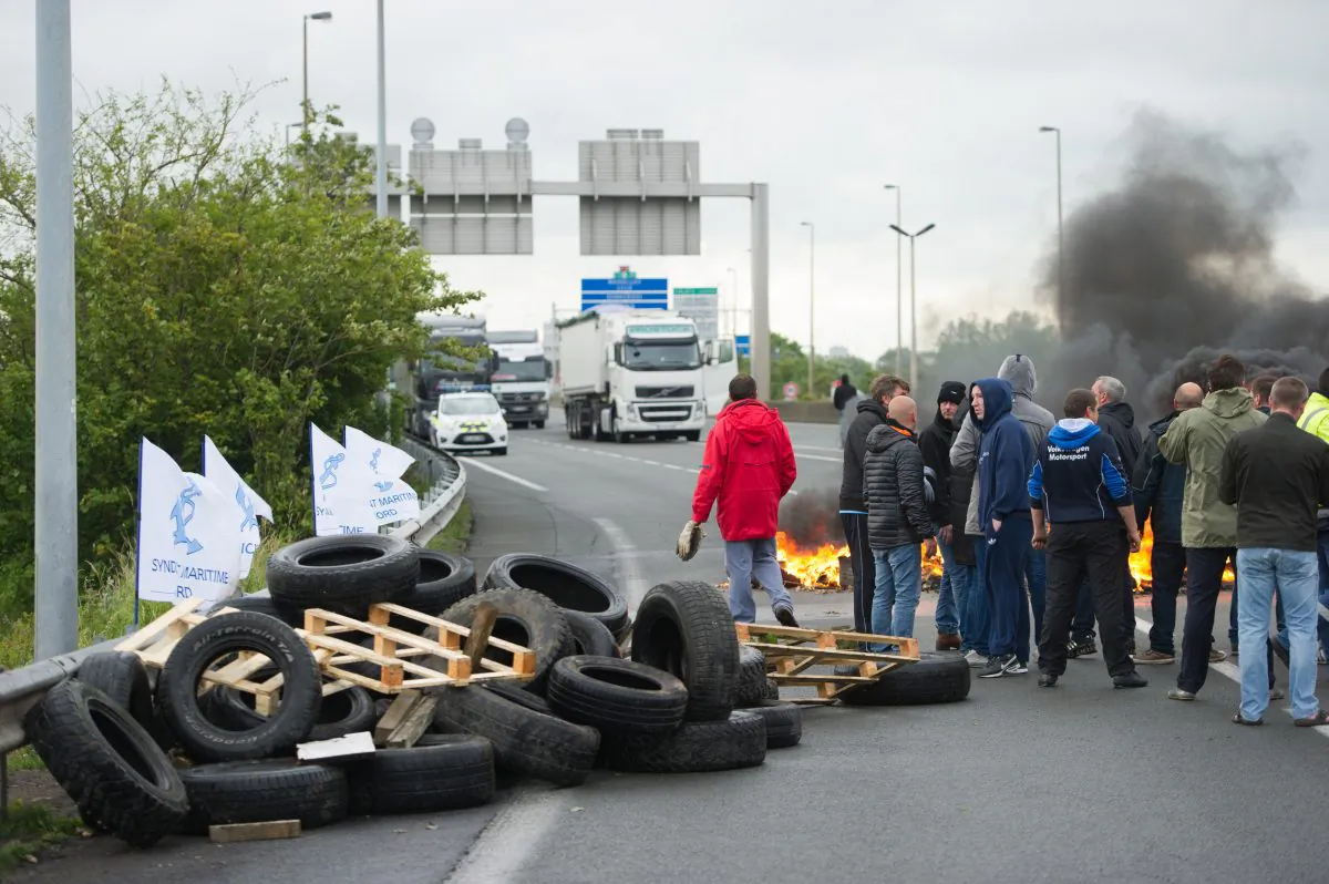 Striking ferry workers burn tyres as they block a ramp leading into the Eurotunnel before being dispersed by riot police in Calais, northern France, Tuesday, June 23, 2015. A strike by workers in the northern French port of Calais has left all passenger ferry service between the city and the English city of Dover suspended and briefly slowed traffic in the Eurotunnel. (AP)