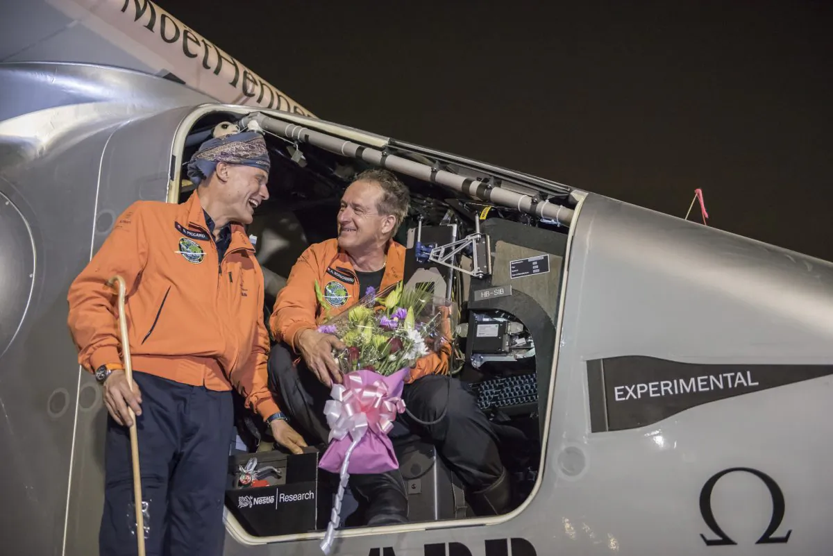 Pilots Andre Boschberg (R), and Bertrant Piccard talk after Solar Impulse 2, a solar-powered airplane, finished up the first day of an historic round-the-world journey that began in Abu Dhabi, UAE, on March 09, 2015 in Muscat, Oman. (Jean Revillard via Getty Images)