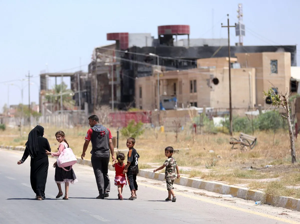 A displaced family walks towards their home in Tikrit, 80 miles (130 kilometers) north of Baghdad, Iraq. Civilians are trickling back into Saddam Hussein’s hometown as they look to start anew, the consequences of a year under Islamic State rule conspicuously written on its charred buildings and damaged homes.(AP/ Hadi Mizban)