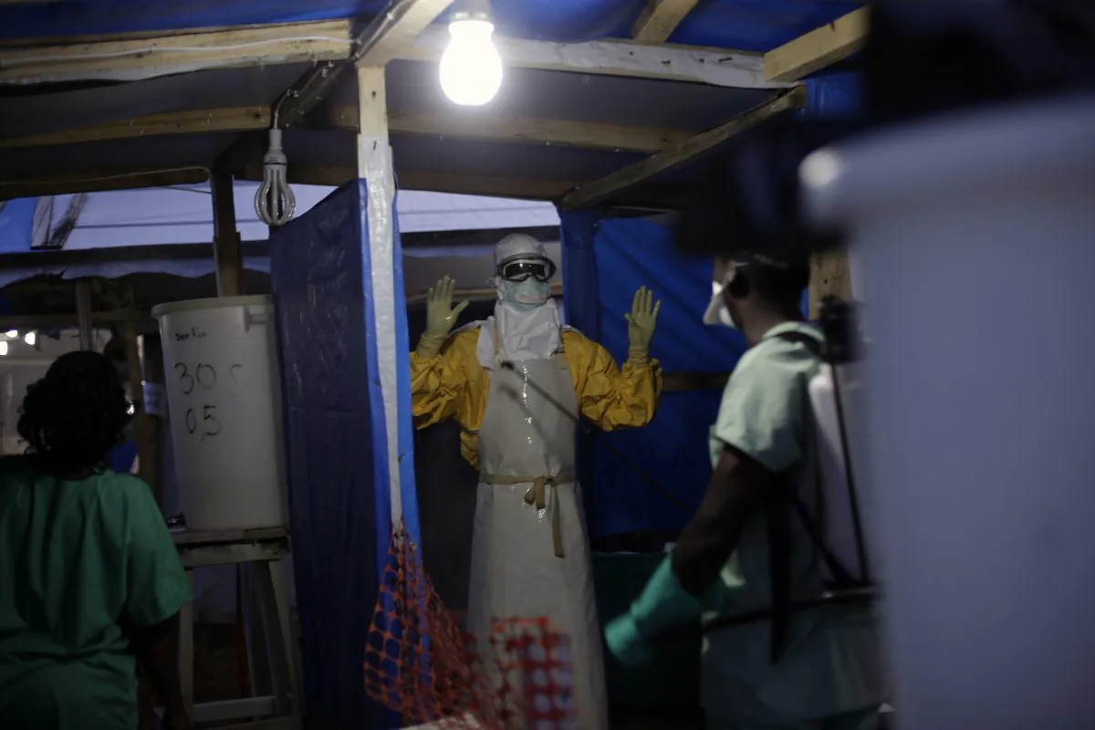 An MSF Ebola heath worker is sprayed as he leaves the contaminated zone at the Ebola treatment centre in Gueckedou, Guinea. Malaria likely killed many more people than Ebola in Guinea during last yearâs biggest-ever outbreak, as experts suspect many people with potential symptoms of the mosquito-spread disease stayed away from health clinics, afraid they might catch Ebola instead, a new study suggests. (AP/Jerome Delay)