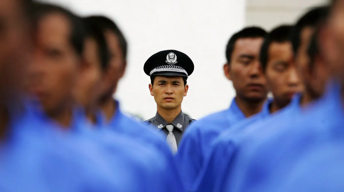 Chinese policeman (C) instructs drug rehab patients to practice marching in a compound at the Kunming Municipal Compulsory Rehabilitation Center on July 8, 2005 in Kunming, Yunnan Province, China.  (Guang Niu/Getty Images)