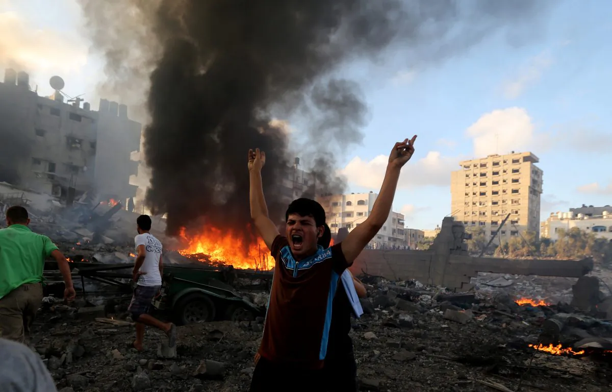 In this July 24, 2014 photo, a Palestinian shouts in an area damaged in an Israeli airstrike in Gaza City, Gaza Strip. (AP Photo/Hatem Moussa)