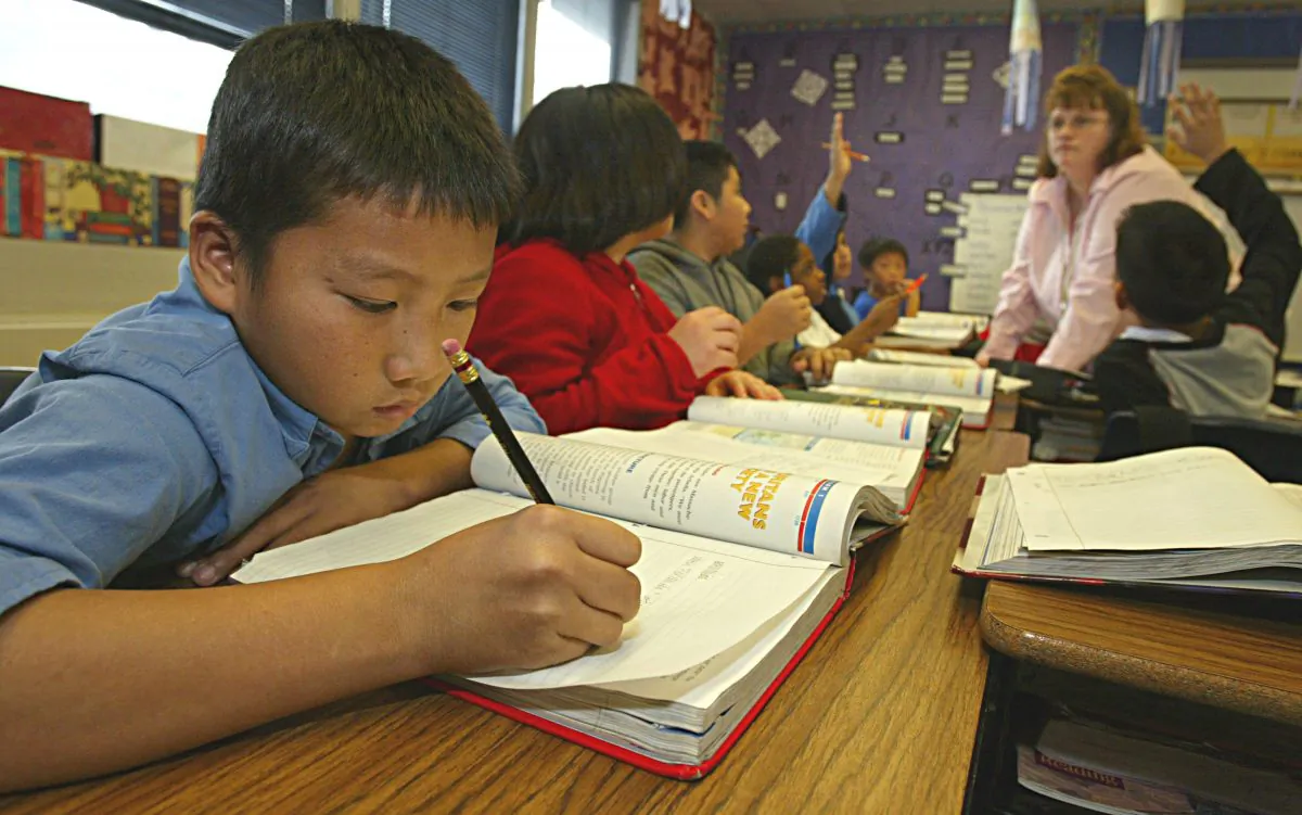 Seng Vang, age 11, practices his writing in his 5th grade class at the Herndon and Barstow Elementary school in Fresno, Calif., on Dec. 10, 2004. (Paula Bronstein/Getty Images)