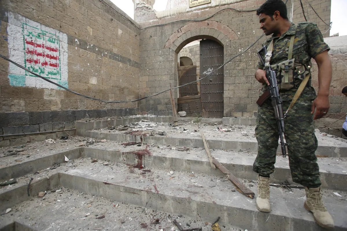 A Shiite Houthi rebel, wearing an army uniform stands guard at the site of an explosion near the old city of Sanaa, Yemen, Saturday, June 20, 2015. (AP Photo/Hani Mohammed)
