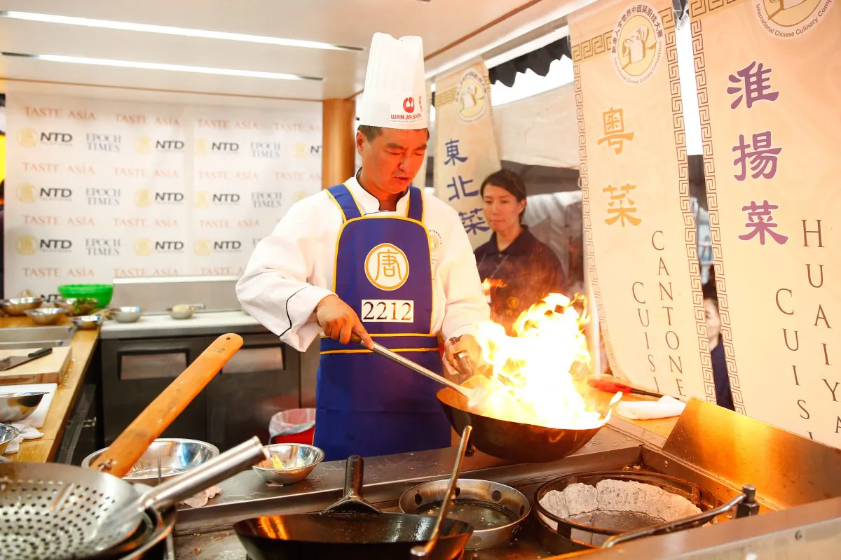 Jiguang Zhang fires up his wok during the Northeastern Cuisine portion of the New Tang Dynasty Television's 7th Annual International Chinese Culinary Competition. The competition is part of the Taste Asia Food Fest held at Times Square in New York City on June 26 and 27, 2015. (Larry Dye/Epoch Times)