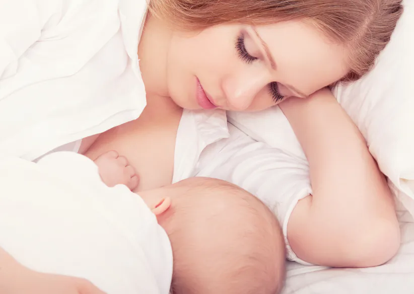 Mother feeding her baby in the bed. (evgenyatamanenko/iStock)