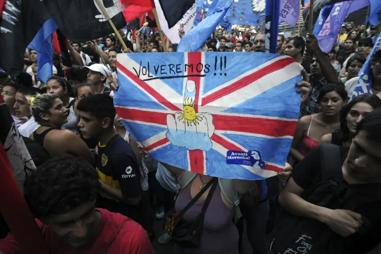 Argentine activists hold a poster reading 'We will be back!' as they take part in a demonstration in front of the British embassy in Buenos Aires on January 24, 2012. (Sergio Goya/AFP/Getty Images)