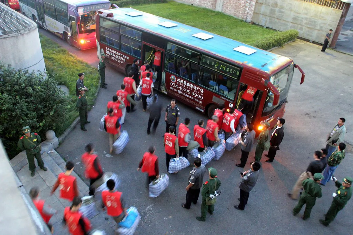 Chinese prisoners board a bus under guard as they move to a newly constructed prison in Shenyang in northeastern China's Liaoning province on Aug. 20, 2005. (AFP/AFP/Getty Images)