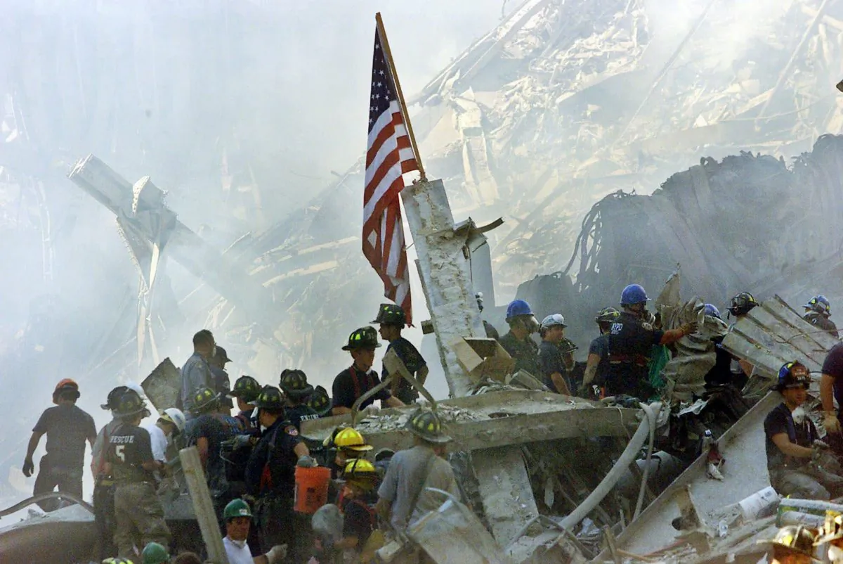 In this Sept. 13, 2001 file photo, a U.S. flag flies over the rubble of the collapsed World Trade Center buidlings in New York. (AP Photo/Beth A. Keiser)