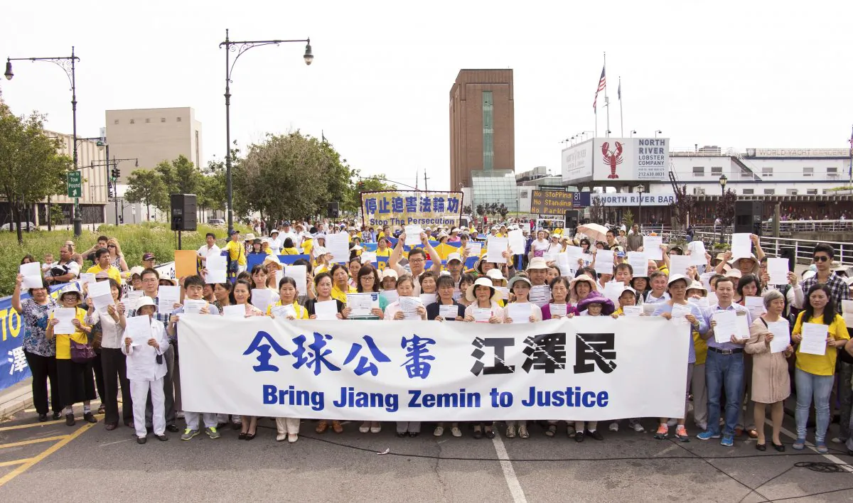 Falun Gong practitioners hold their criminal complaints at a rally in front of the Chinese consulate in New York City on July 3, 2015, to support the global effort to sue Jiang Zemin. (Larry Dye/Epoch Times)