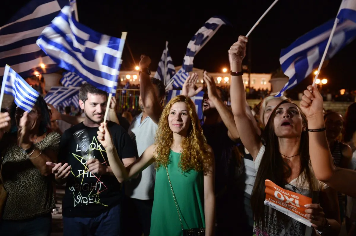 People celebrate in Athens on July 5, 2015 after the first exit-polls of the Greek referendum. Over 60 percent of Greeks rejected further austerity dictated by the country's EU-IMF creditors in a referendum, results from 20 percent of polling stations showed. (LOUISA GOULIAMAKI/AFP/Getty Images)